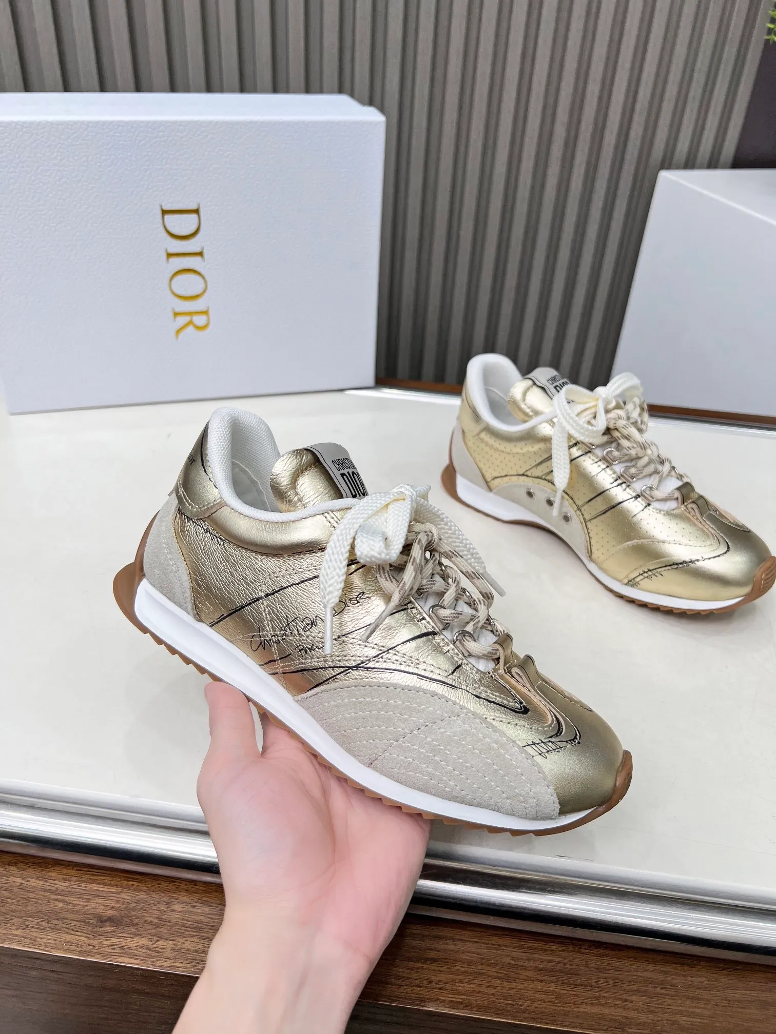 👟👟Ex-factory price 560👟👟 This D-Sketch sneaker is a new product of the 2025 spring and summer ready-to-wear series, highlighting the classic retro aesthetics. Crafted from gold-tone crinkled sheepskin and gold-toned laminated calfskin, it features a printed logo inspired by the shoe's production stages, as well as beige suede calfskin panels and double laces. Hand-written Christian Dior Paris signature on the side, Christian Dior Paris signature panels and plaques on the heel and tongue. Paired with two-tone slim rubber soles, they add a touch of couture to any casual look. Code number: 35~45 Color: black white gold silver
